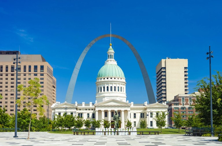 The Gateway Arch rising behind a domed historic courthouse in St. Louis