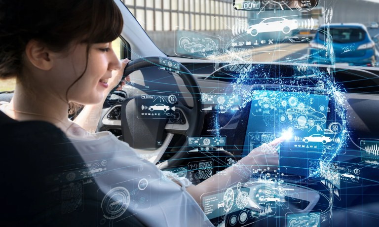 Woman in a car touching a futuristic touchscreen showing vehicle data displays
