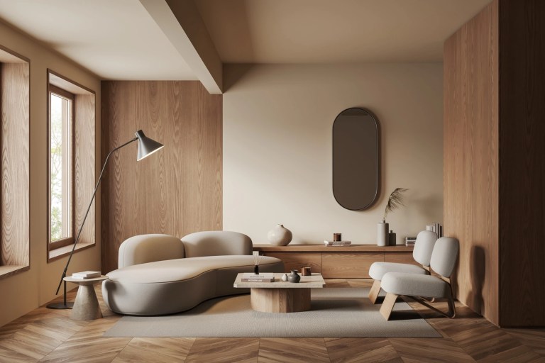 Minimalist living room with a curved cream sofa, wood panelling and herringbone floor