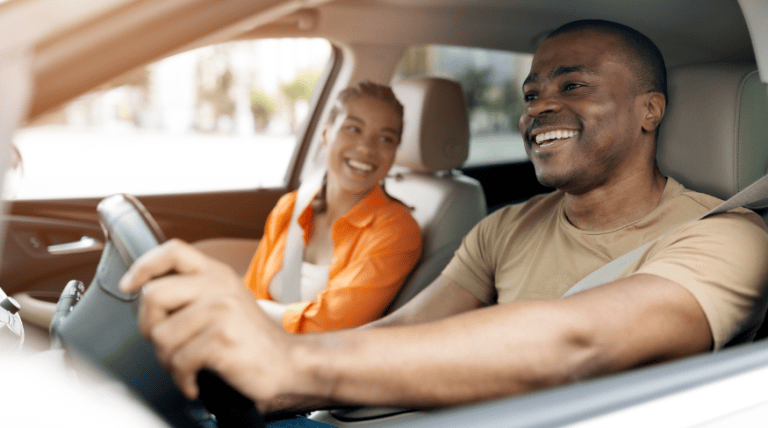 Happy couple driving in car