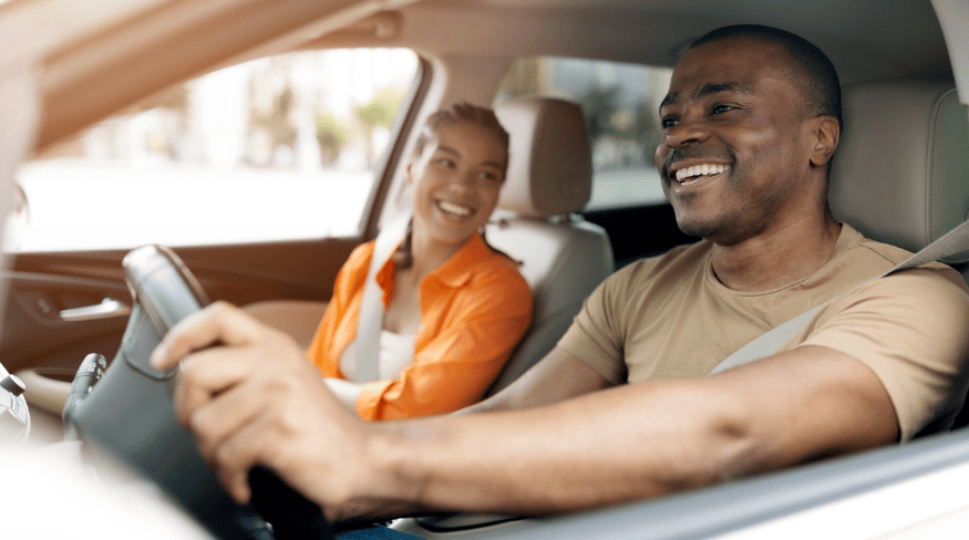 Happy couple driving in car